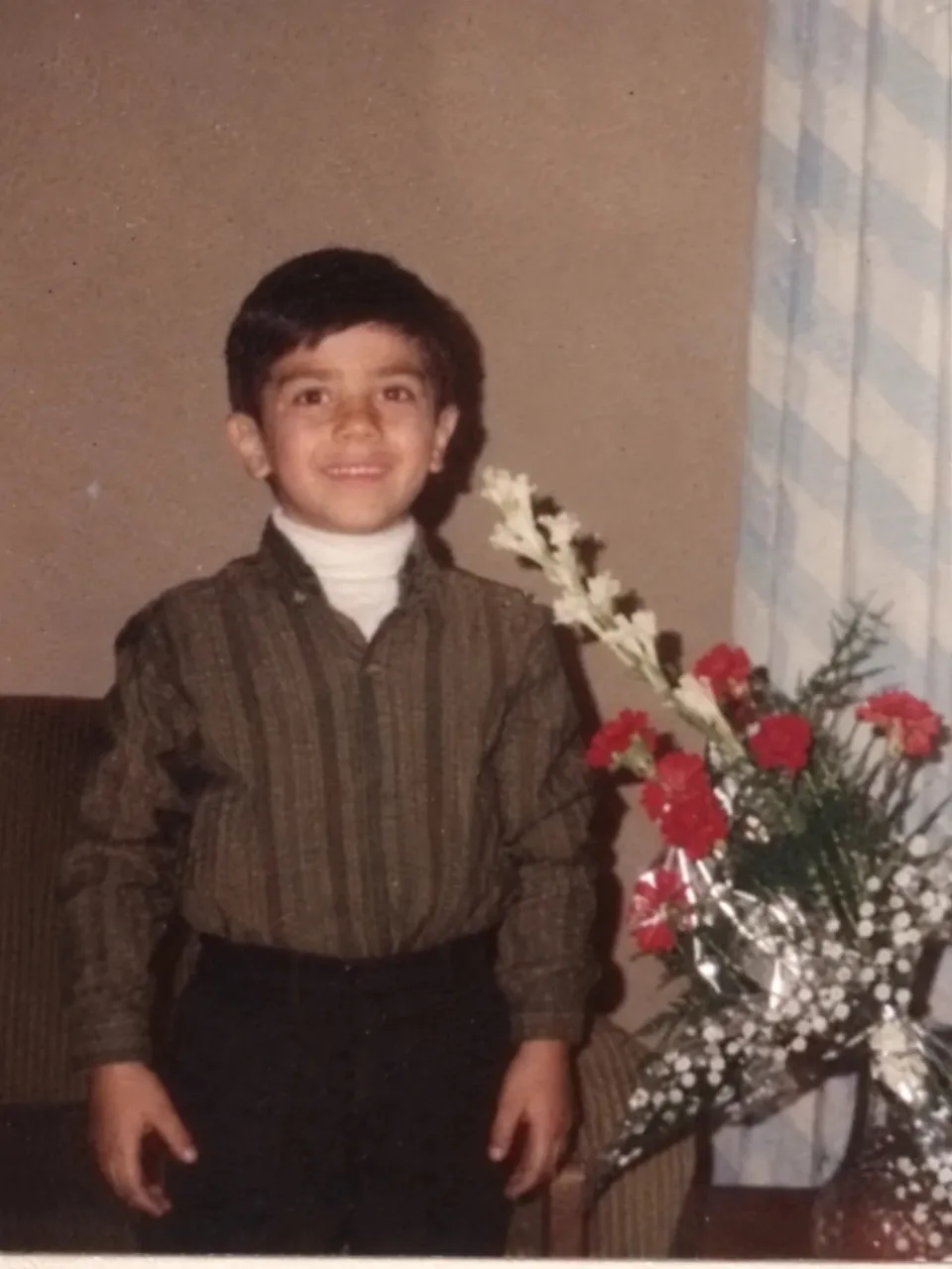 محمد بی‌باک در کودکی، کنار یک دسته گل